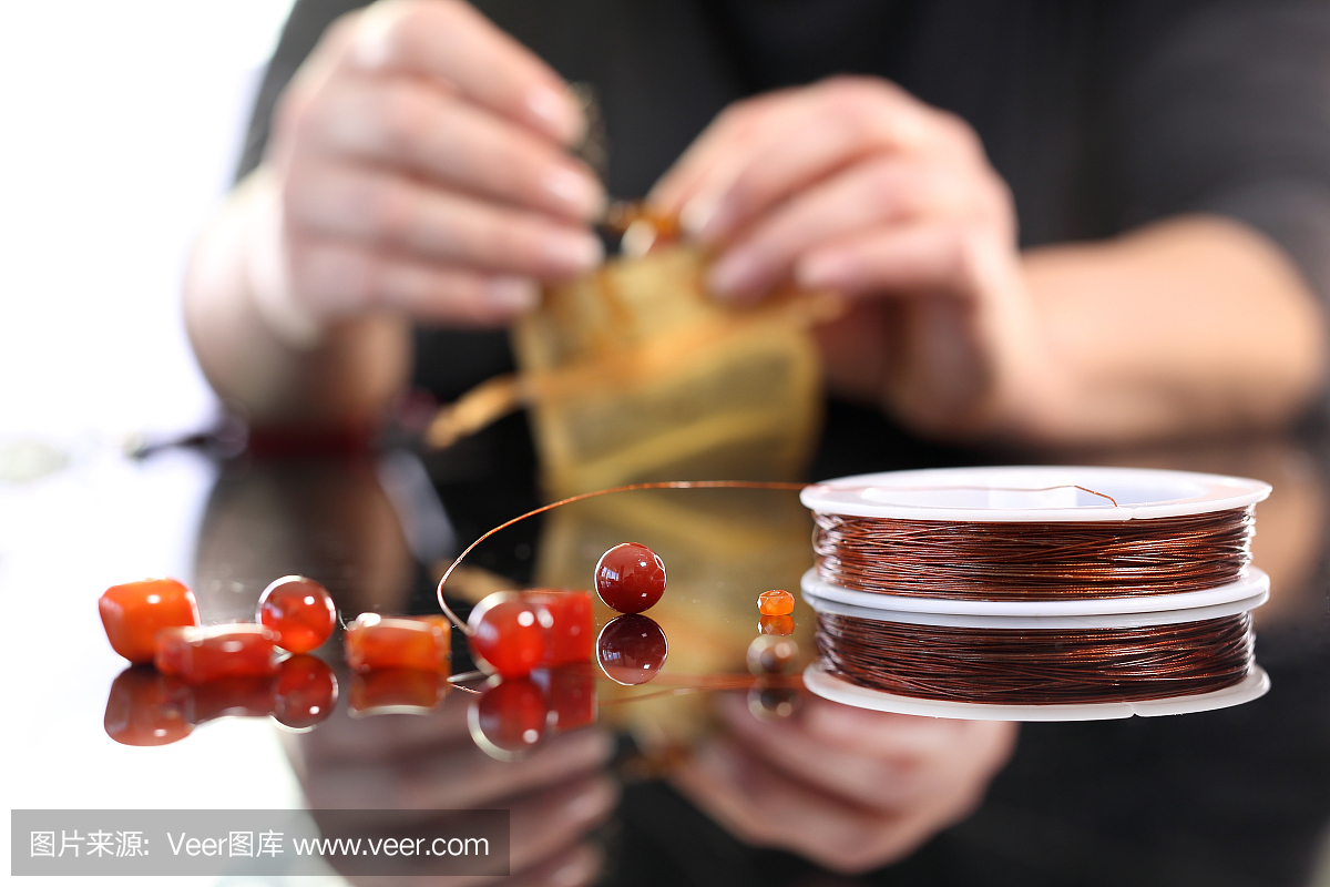 工廠里,一個女人拿著琥珀做的首飾
